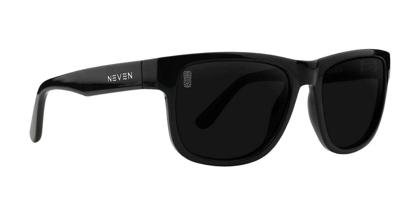 The Sade by Neven Eyewear are glossy black sunglasses with thick frames, dark polarized lenses, and slightly curved arms. "NEVEN" is printed in silver on the left arm near the hinge. Classic rectangular style for comfort and style.