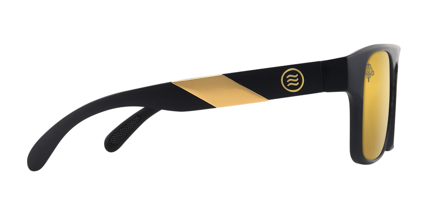 The Golden Banana sunglasses by Neven Eyewear feature a sporty black frame with wide arms, metallic gold diagonal accent, circular gold logo, and yellow polarized UV400 lenses. The modern design includes a slight mirror finish.