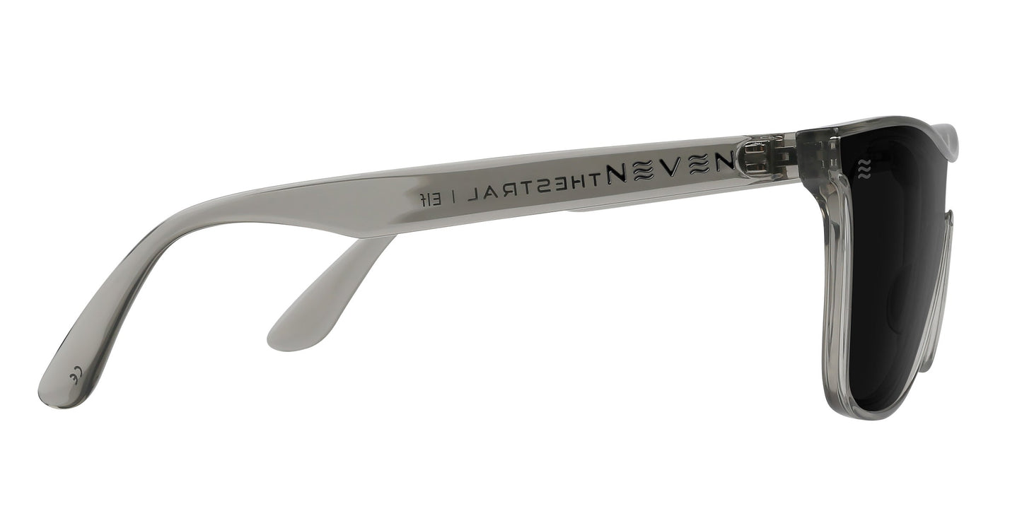 Side view of Neven Eyewear’s Elf sunglasses in translucent gray with black lenses. The temple arm features “NEVENEYEWEAR” and a small logo. Glossy finish, exposed hinges, and the frame offer UV400 protection.