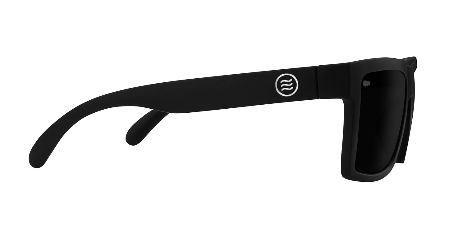 Side view of Neven Eyewear’s Lowrider XL sunglasses in matte black, featuring thick arms, dark polarized lenses, a small white circular logo by the hinge, and an oversized rectangular modern design on a white background.