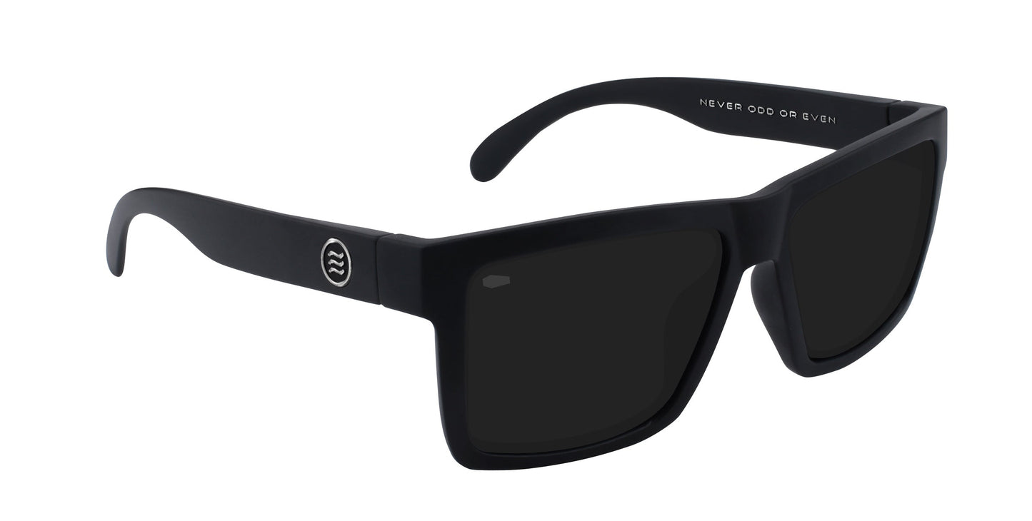 The Neven Eyewear Lowrider XL sunglasses feature a bold modern design with matte black oversized rectangular frames, dark lenses, "NEVER ODD OR EVEN" on the inner arm, and a small circular logo with stylized lines on the outer arm.