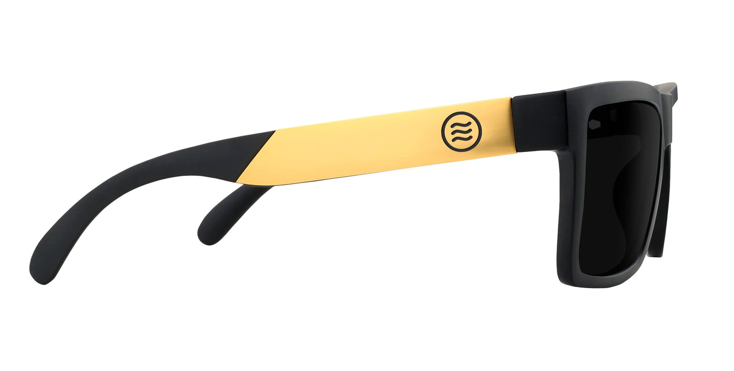 Neven Eyewear's Prospector XL sunglasses from the Tombstone XL Collection feature polarized black lenses and frames, yellow arms with black tips, and a circular logo with three wavy lines for bold side-view contrast.