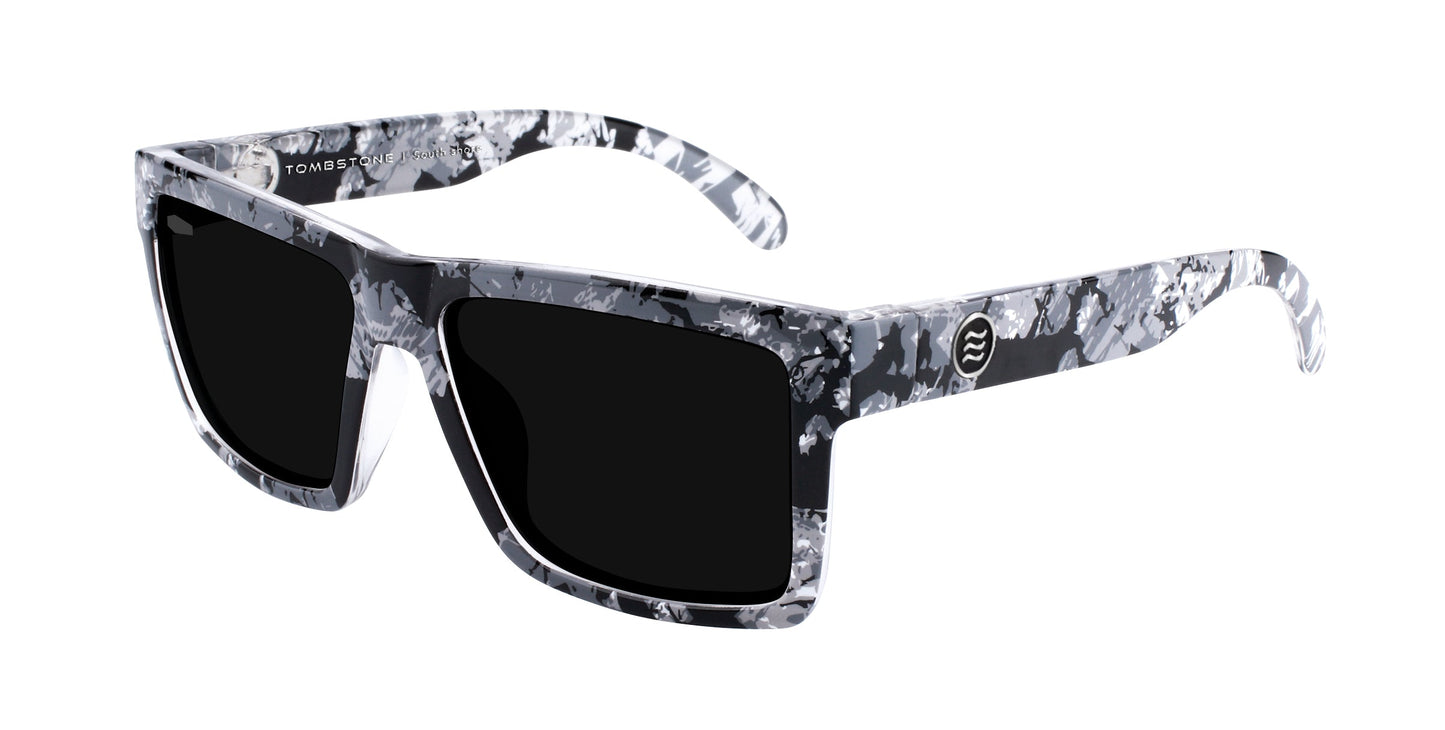 Neven Eyewear’s South Shore sunglasses feature a bold, rectangular frame with a black, white, and grey marble pattern, dark lenses for contrast, and a small round logo on the temple.