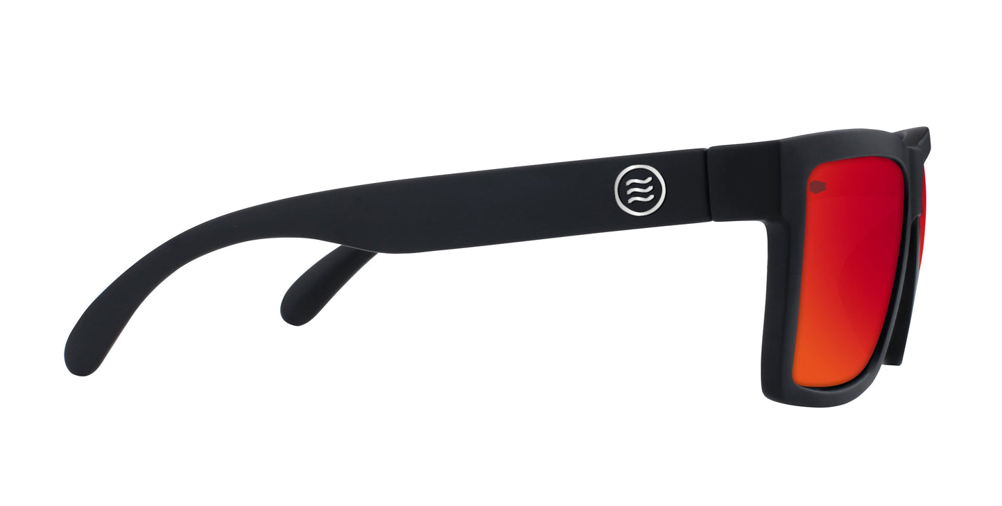 A pair of black-framed Neven Eyewear Supernova sunglasses from the Tombstone Collection with thick arms, red-orange mirrored lenses, and a white wave logo on the side, shown in profile against a white background.