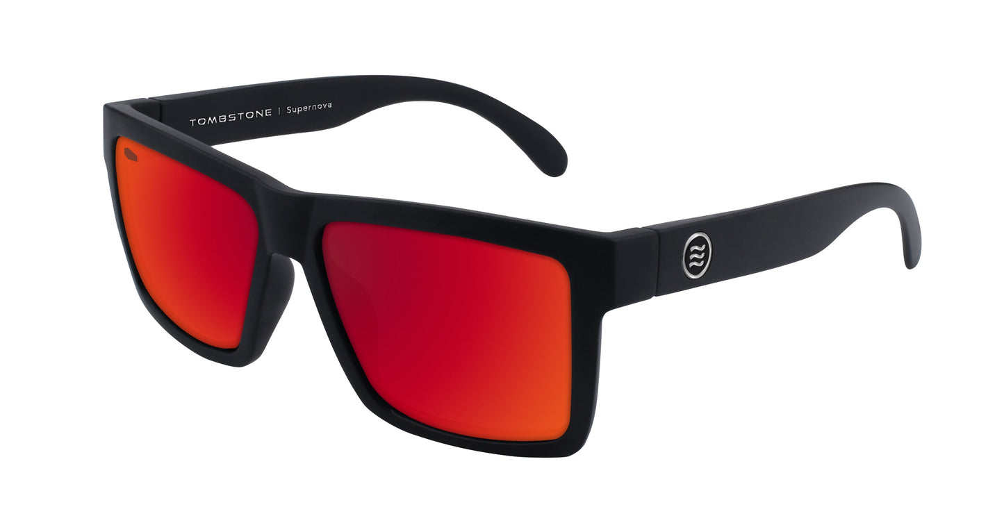 A pair of black Neven Eyewear Supernova sunglasses with thick frames, red-orange mirrored lenses, a round white logo, and "TOMBSTONE | Supervision" on the right temple from the Tombstone Collection.