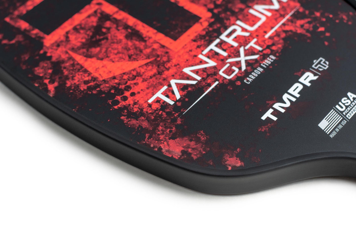 Close-up of the Tantrum GXT by TMPR Sports, a black carbon fiber pickleball paddle with red textured design, "Tantrum GXT" and "TMPR" text, USA Pickleball Approved logo—highlighting premium branding and vibration dampening on white background.