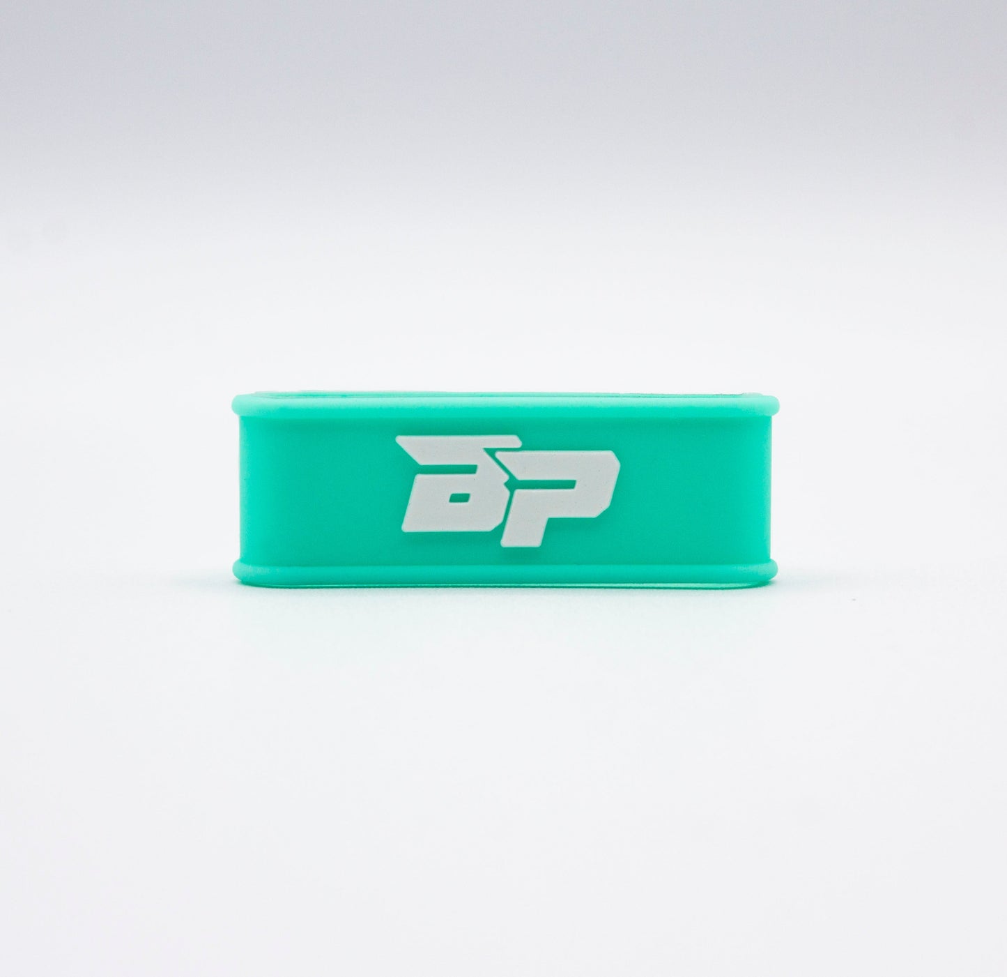 The Bodhi Performance Paddle Band is a turquoise, rectangular silicone wrist band with a bold, white BP logo on the front—flexible and shown on a plain white background. Use as a stylish pickleball paddle accessory or wristband.