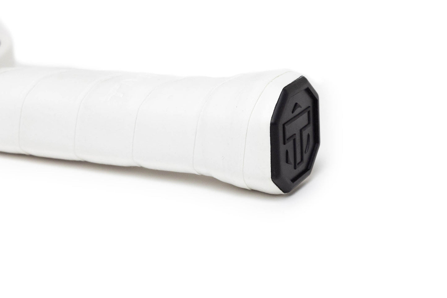 Close-up of the TMPR Sports Terra LX pickleball paddle handle with a black octagonal end cap, featuring a raised geometric logo. The smooth white grip tape and vibration dampening tech stand out against the white background.