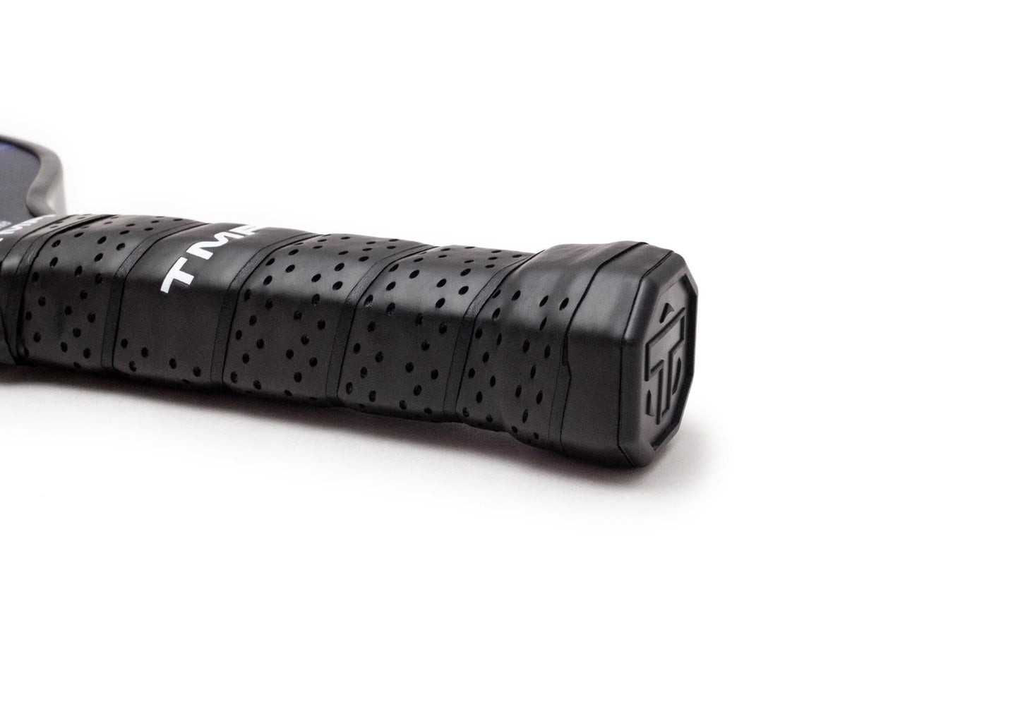Close-up of the TMPR Sports Terra LX | Indigo Ice tennis racket handle in black with a perforated, hybrid grip. The tightly wrapped end features a stylized “TF” logo, and part of the shaft shows the enhanced spin white logo, all set against a white background.
