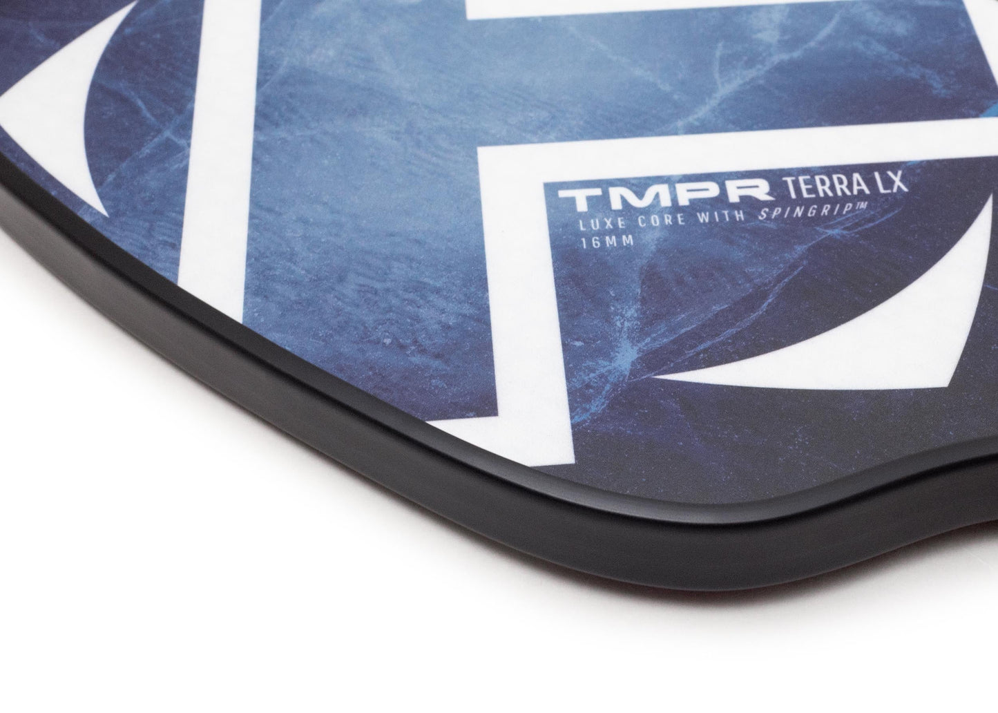 Close-up of the TMPR Sports Terra LX | Indigo Ice pickleball paddle in blue with white geometric designs, featuring a hybrid design for exceptional spin control and a smooth edge with a black rim.