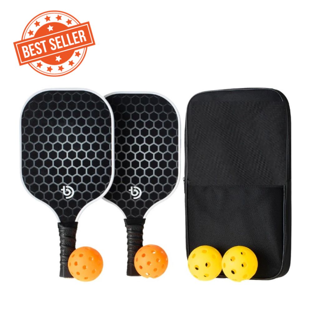 The Big Dink Bundle by The Big Dink includes two black carbon fiber paddles with a hexagonal pattern, white edges, grip tape handles, three yellow balls, and a black carrying case. A red Best Seller stamp appears in the corner.