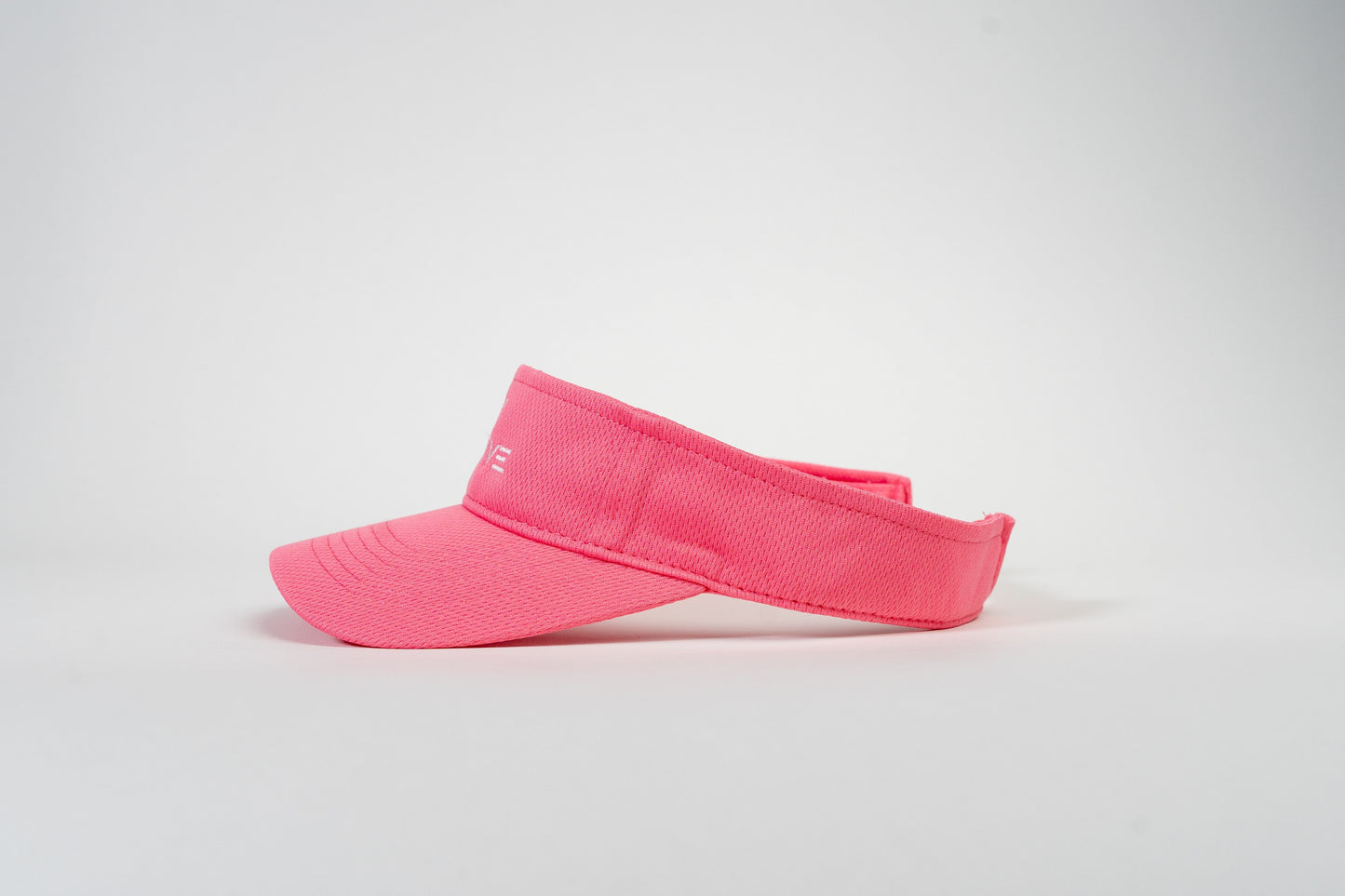 The Thrive Elite Tour Visor by Thrive Pickleball is shown in bright pink against a white background. It features a curved brim, moisture-wicking fabric, adjustable back strap, and subtle white stitching on the front left side.