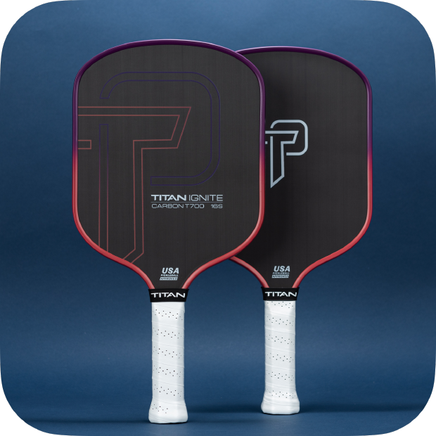 Two Titan Pickleball Titan Ignite 16S carbon fiber paddles stand upright against a dark blue background, featuring black surfaces, red edges, white grips, and bold T and P designs—the perfect choice for your next pickleball paddle.
