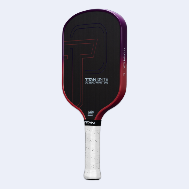 The Titan Pickleball Titan Ignite 16S is a carbon fiber paddle with a dark face, subtle geometric lines, "Titan Ignite Carbon T700 16S" text, a red-to-purple fade edge, and a textured white grip with the USA Pickleball Approved logo.