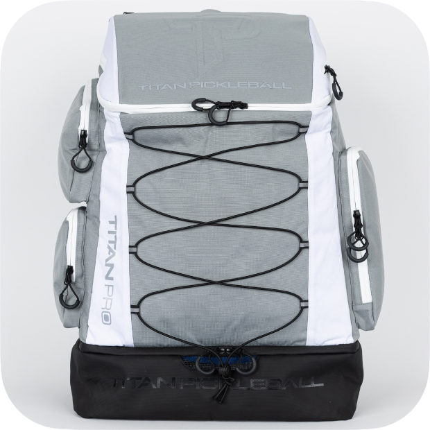 The Titan Pickleball Backpack by Titan Pickleball features a gray and white design, black zipper pulls, side pockets, black bottom compartment, front bungee cords for extra storage, and a sturdy high-capacity build.