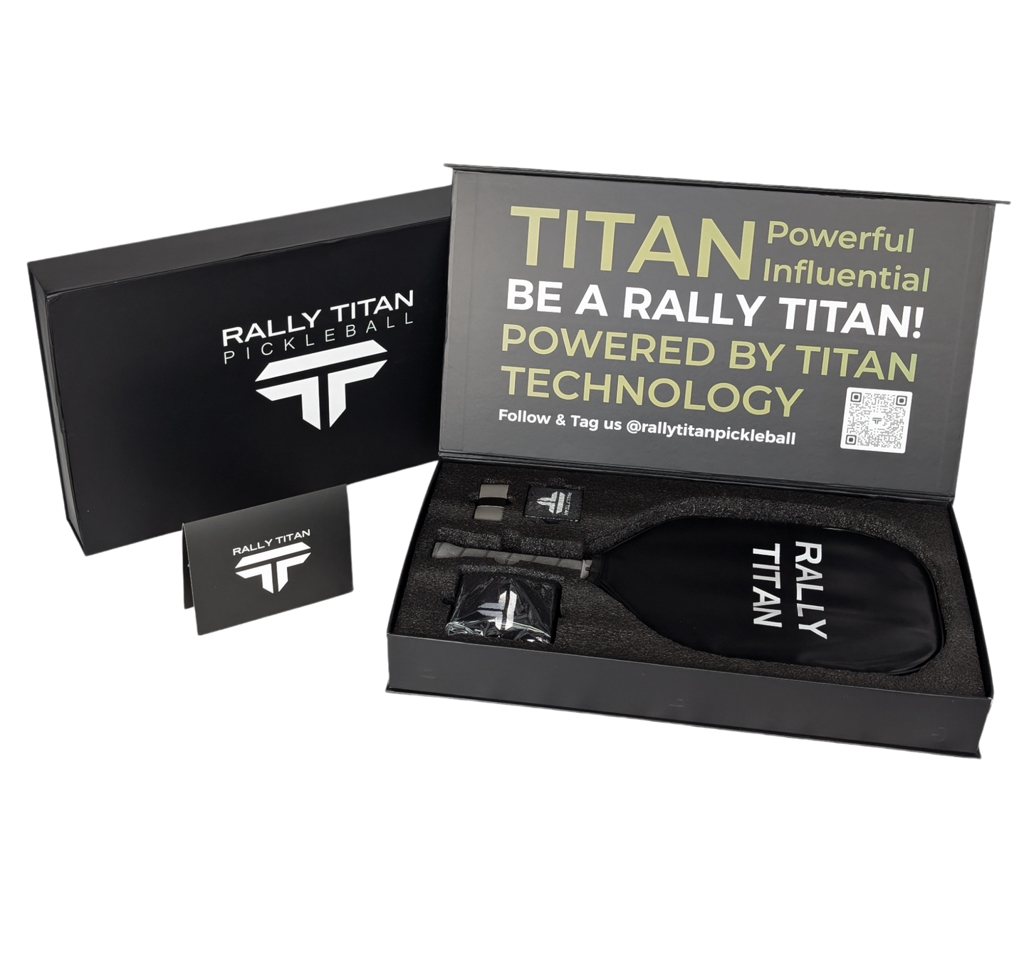 A Rally Titan Pickleball gift box is open, displaying a grey Titan Pro 16MM paddle (T700 Carbon Surface, Thermoformed Unibody), two black accessories, an instruction card, and a lid reading: TITAN Powerful Influential. BE A RALLY TITAN!.