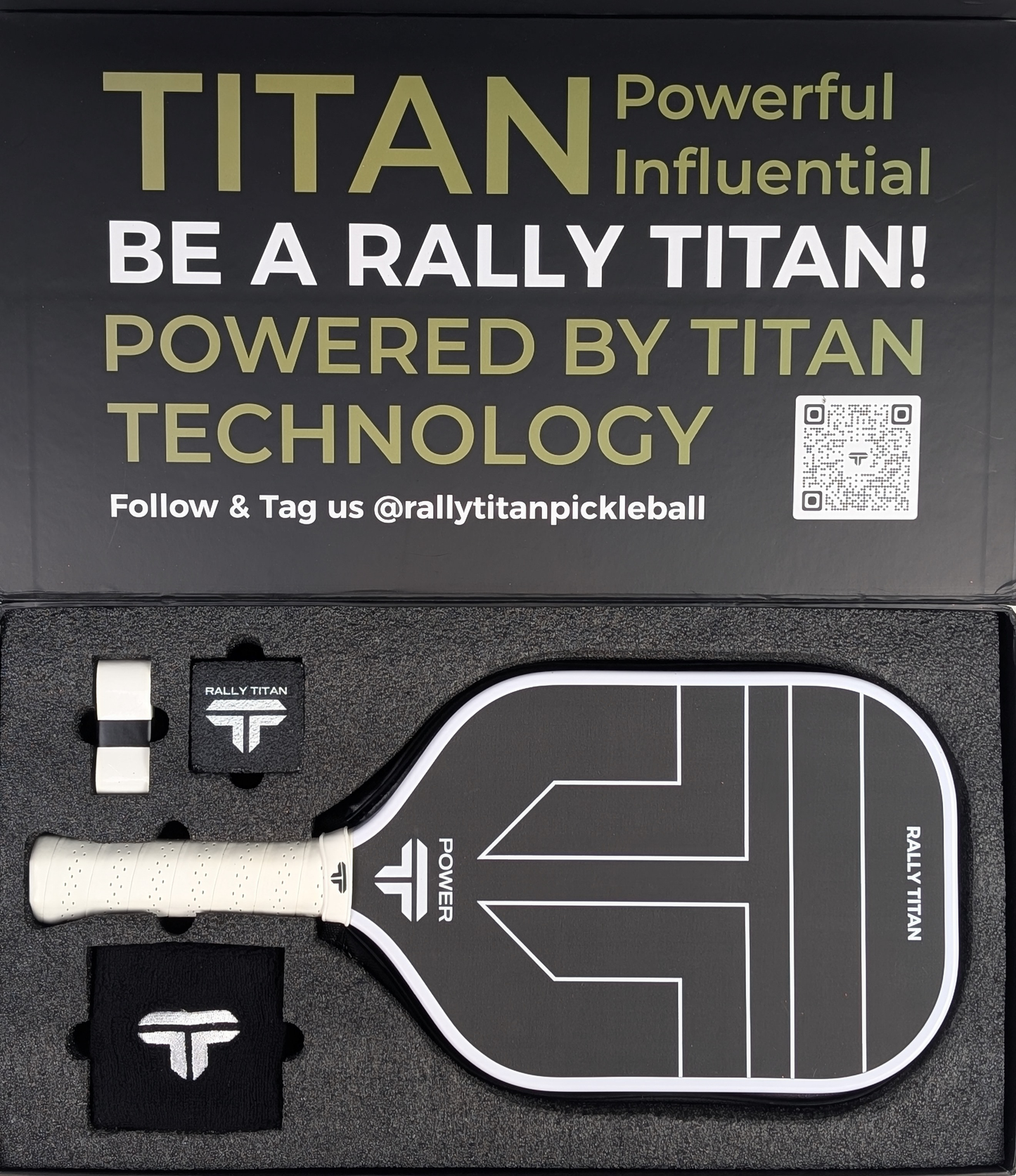 A Titan Power 14MM paddle (T700 Titan Carbon Friction Surface, white grip) by Rally Titan Pickleball rests in a box with two black wristbands and two overgrips. The lid shows: TITAN Powerful Influential, QR code, and social media handle.