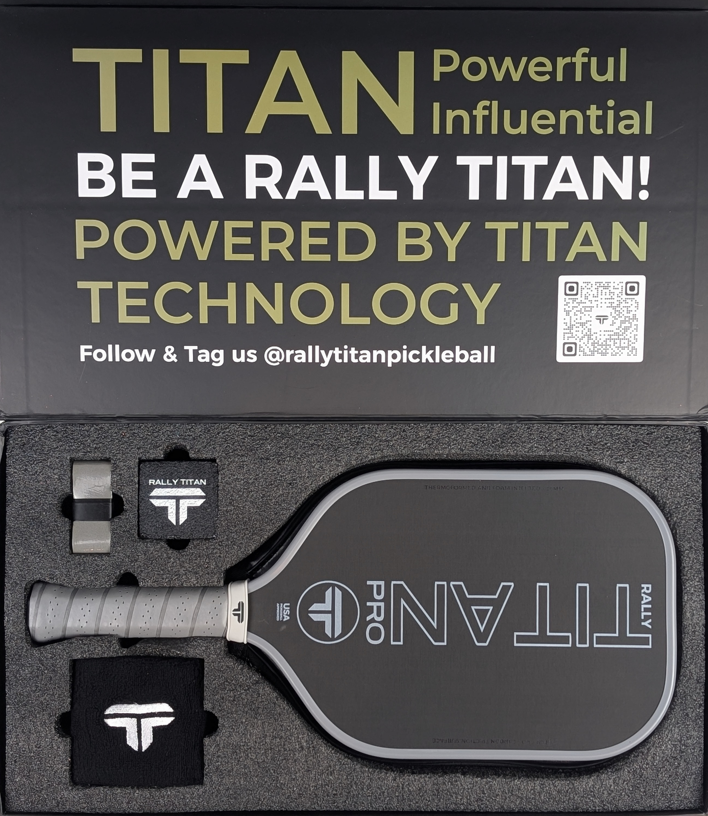 The Rally Titan Pickleball Titan Pro 16MM paddle (T700 carbon friction surface, thermoformed unibody, foam-injected walls, grey) is boxed with two black sweatbands and a keychain; the lid features bold TITAN text, a QR code, and a gray grip handle.