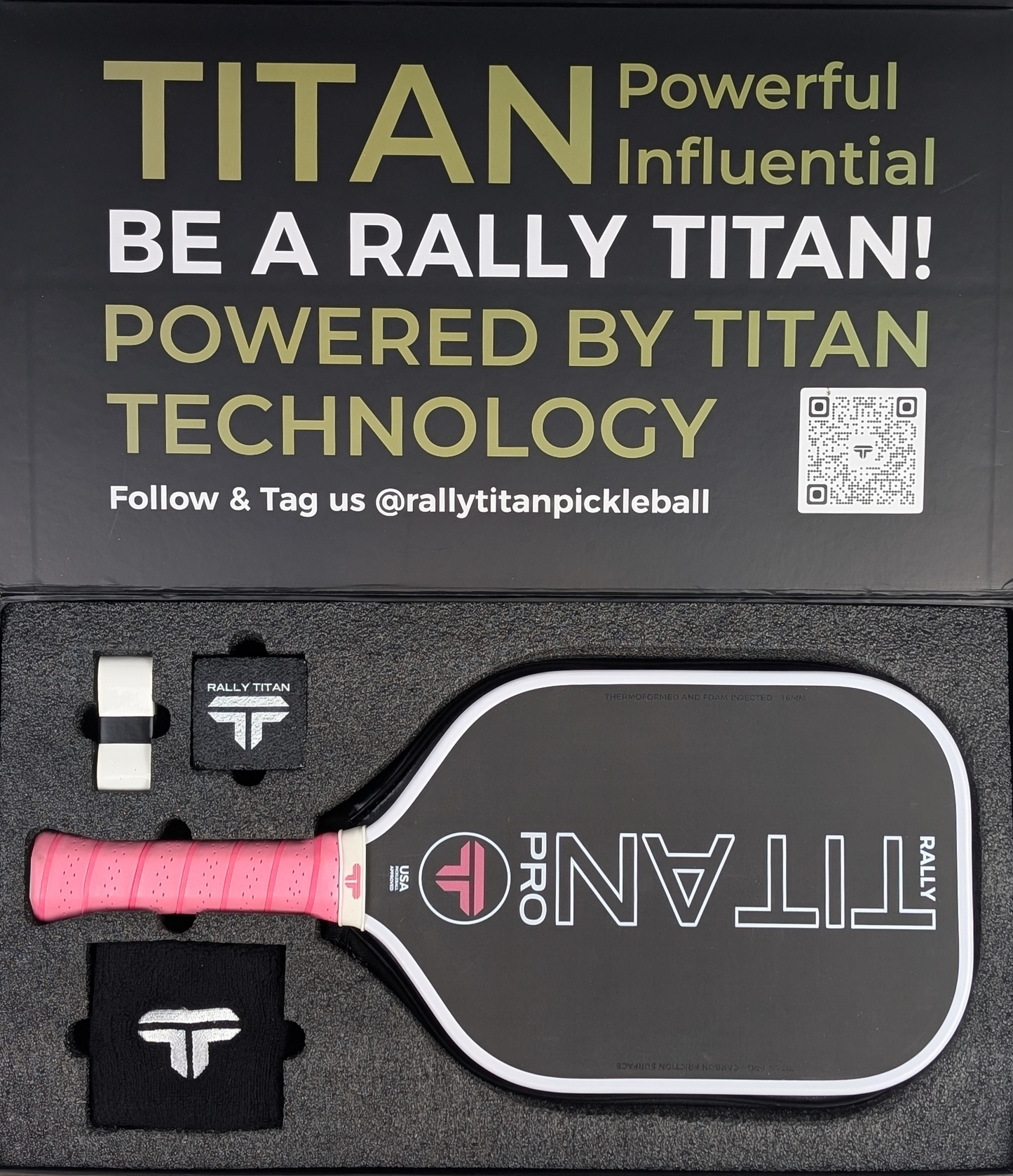 A Rally Titan Pickleball Titan Pro 16MM paddle with a T700 Titan carbon friction surface and white with pink accents is displayed in a custom foam case with two wristbands, booklet, and "TITAN Powerful Influential" box lid.