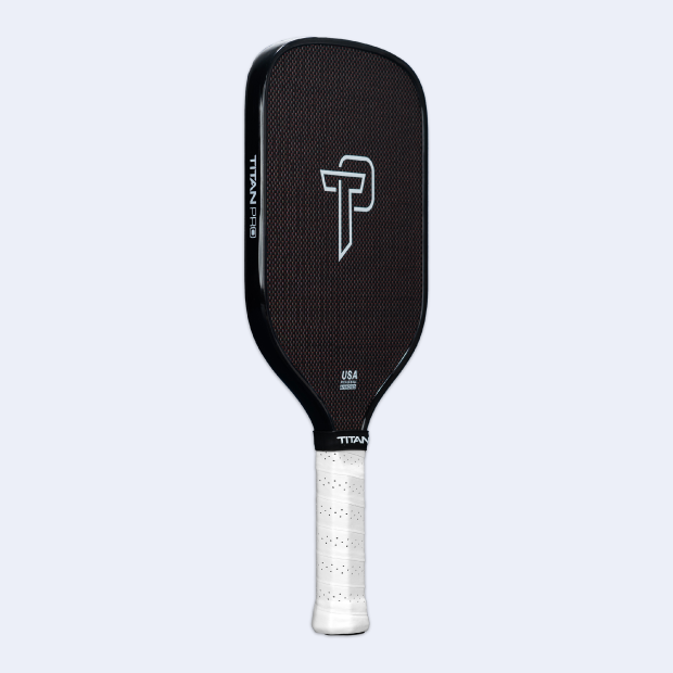 The Titan Pickleball Titan Pro Titanium 14L features a textured black carbon fiber face, a white TP logo at the center, "TITAN PRO" on the edge, and a white grip handle. The paddle is shown upright against a plain light gray background.