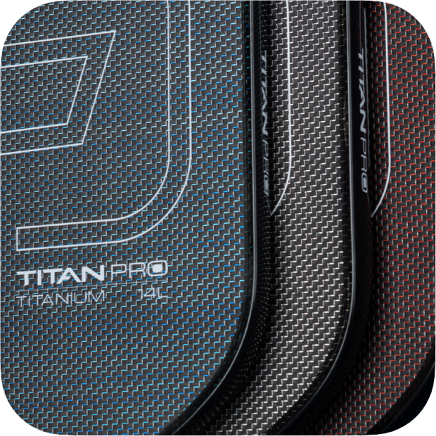 Close-up of three carbon fiber Titan Pickleball paddles in blue, black, and red, each labeled “Titan Pro Titanium 14L” with a fine grid pattern and rounded edges, side by side with lighting accentuating their textured surfaces.