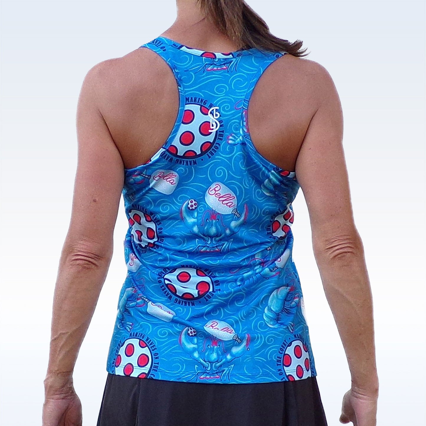 A woman with a ponytail is seen from the back, wearing the Pickleball Bella PB Racerback Tank Lobster Monster with a black skirt, set against a light gradient background.