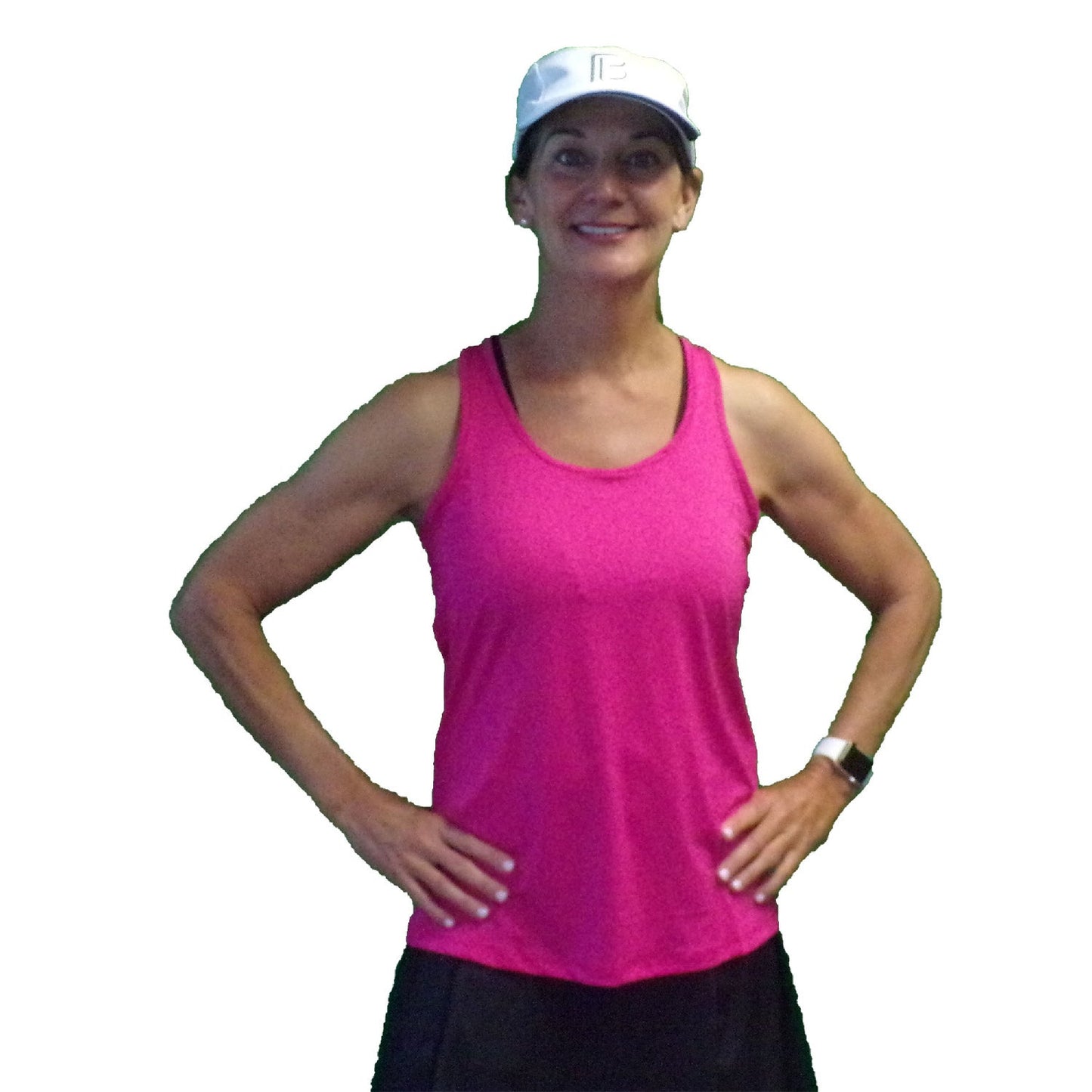 A woman stands smiling with hands on hips, wearing a Pickleball Bella PB Racerback Tank Pink, white baseball cap, black skirt, and smartwatch against a white background.