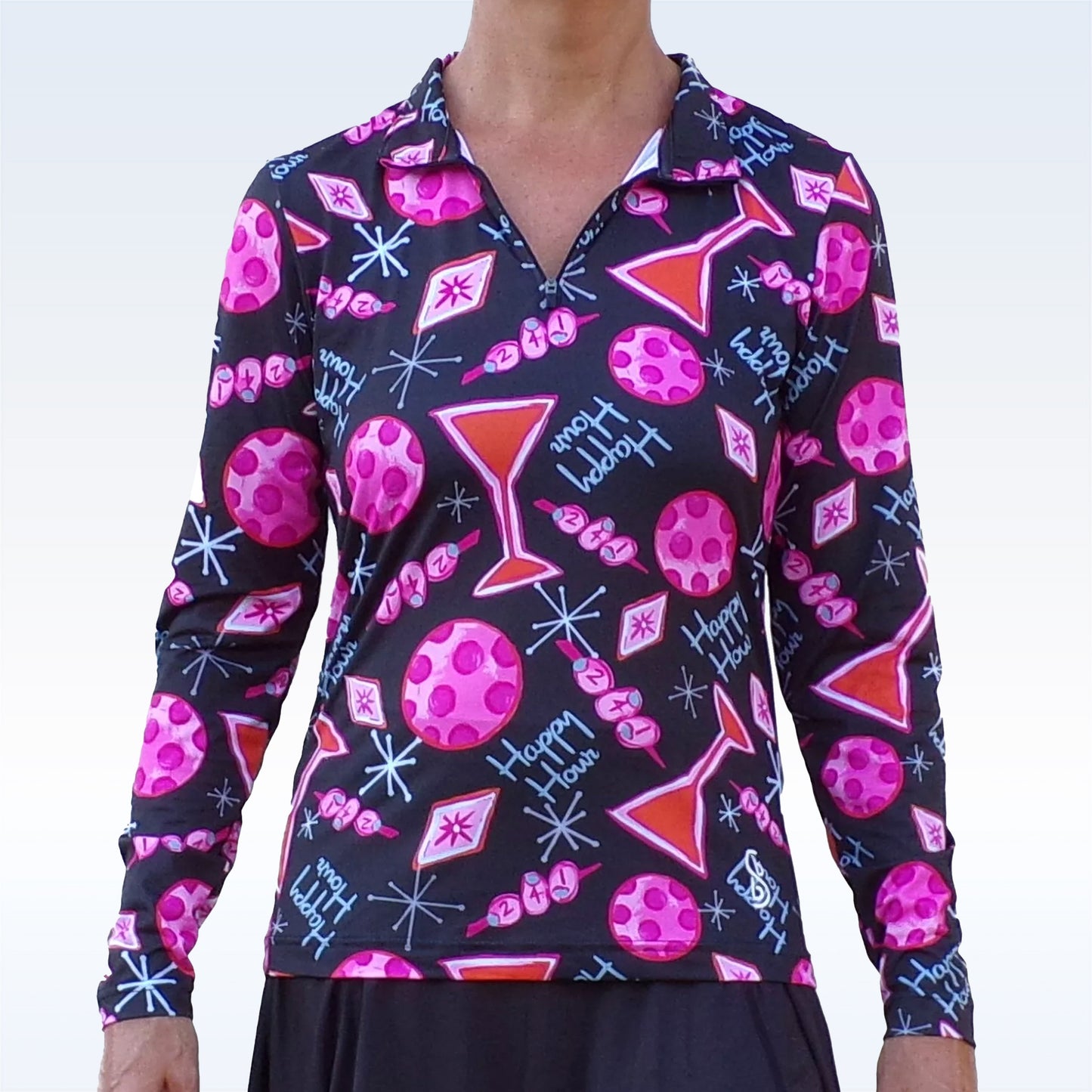 A person wears the Pickleball Bella PB 1/4 Zip Long Sleeve Martini 2-4-1 Happy Hour top, featuring a black background, pink martini glass and “Happy Hour” designs, SPF 50+ UV protection; only the torso and neck are visible.