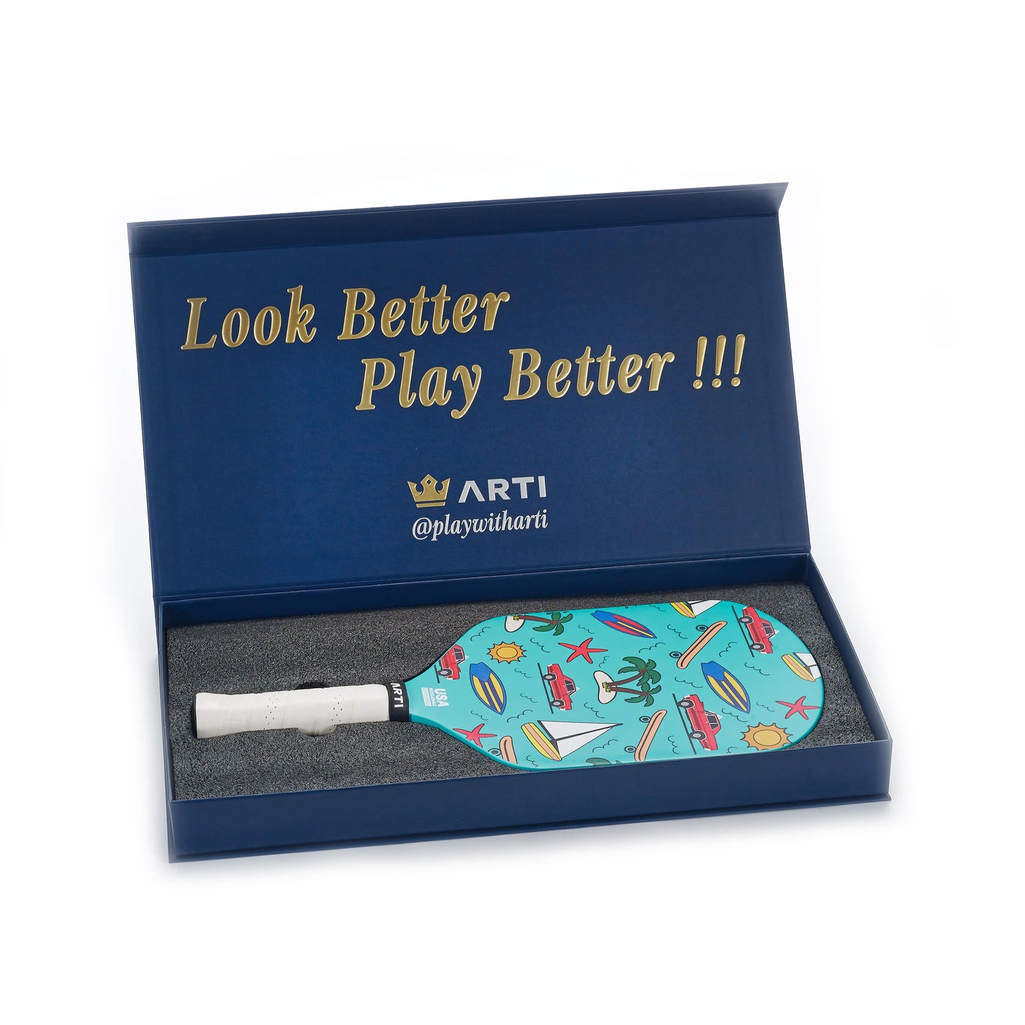 The ARTI Carbon Fiber "CALIFORNIA" Paddle by ARTI comes in a blue gift box with gold “Look Better Play Better !!!” and “ARTI @playwitharti” text, featuring beach-themed icons—perfect for vibrant coastal play.
