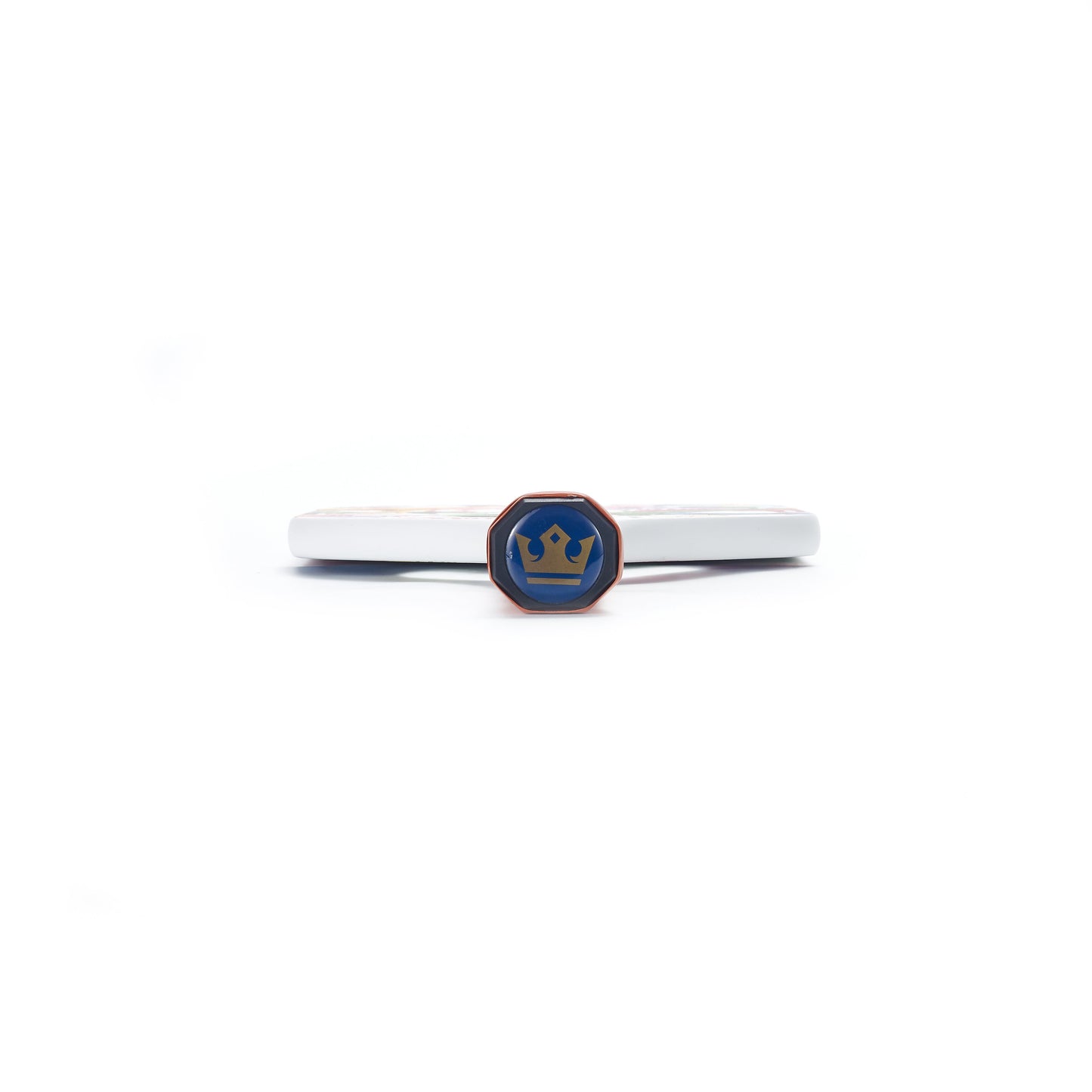 A white, circular ARTI Carbon Fiber EXOTIC TRIPIMAL "Animal" paddle by ARTI is shown side-on with a small blue emblem featuring a gold crown. This USAPA-approved carbon fiber pickleball paddle is set against a plain white background.