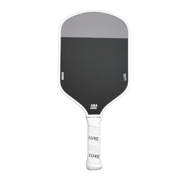 A black carbon fiber Dinker paddle by LUXE Pickleball with a white grip, USA Pickleball Approved label, and a modern rectangular face is shown on a plain white background.