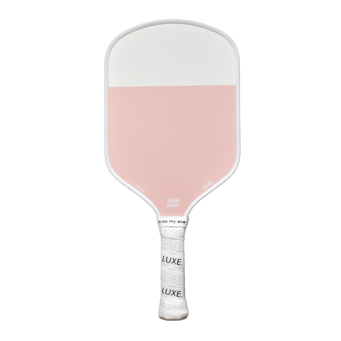 The Dinker paddle by LUXE Pickleball features a rectangular face—half white, half light pink—and a white grip with “LUXE.” and “kiss my ace.” in black. This USA Pickleball Approved paddle stands out against a plain white background.