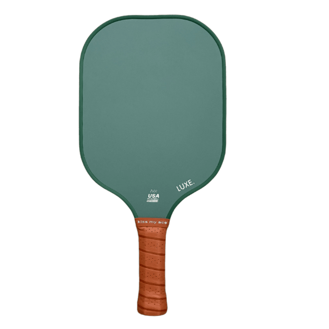 The Core Collection pickleball paddle by LUXE Pickleball features green carbon fiber with rounded edges, a brown textured grip, "LUXE." on the face, "kiss my ace" at the base, and a USA Pickleball Approved textured surface. White background.