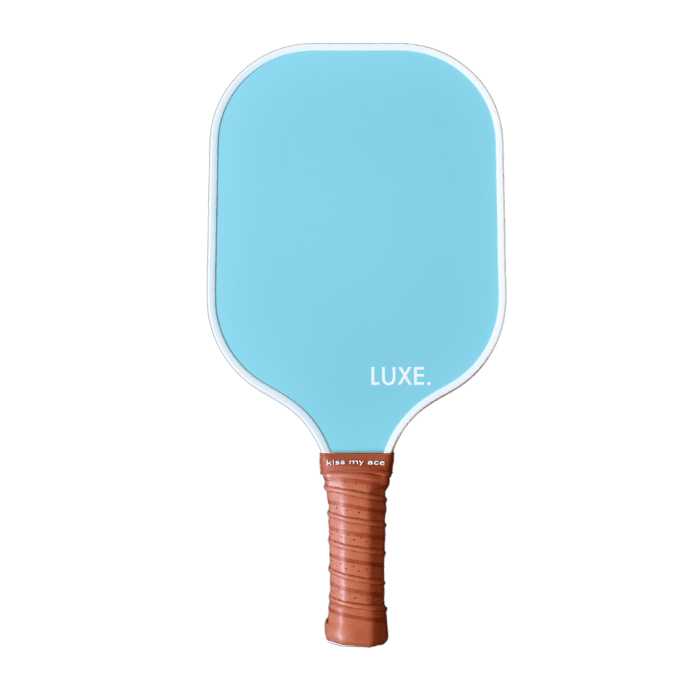 The Aesthetic Solids - Ace paddle by LUXE Pickleball is a blue, rectangular paddle with rounded edges, a brown textured handle, LUXE. in white on the face, and "kiss my ace" on the handle. USA Pickleball Approved. White background.
