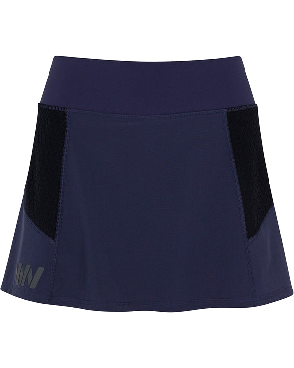 The Wringer Wear Moab Skirt features a navy blue color, wide stretchy waistband, black textured side panels, moisture-wicking fabric, subtle overlapping M logo on the lower left, and a smooth, slightly flared silhouette.