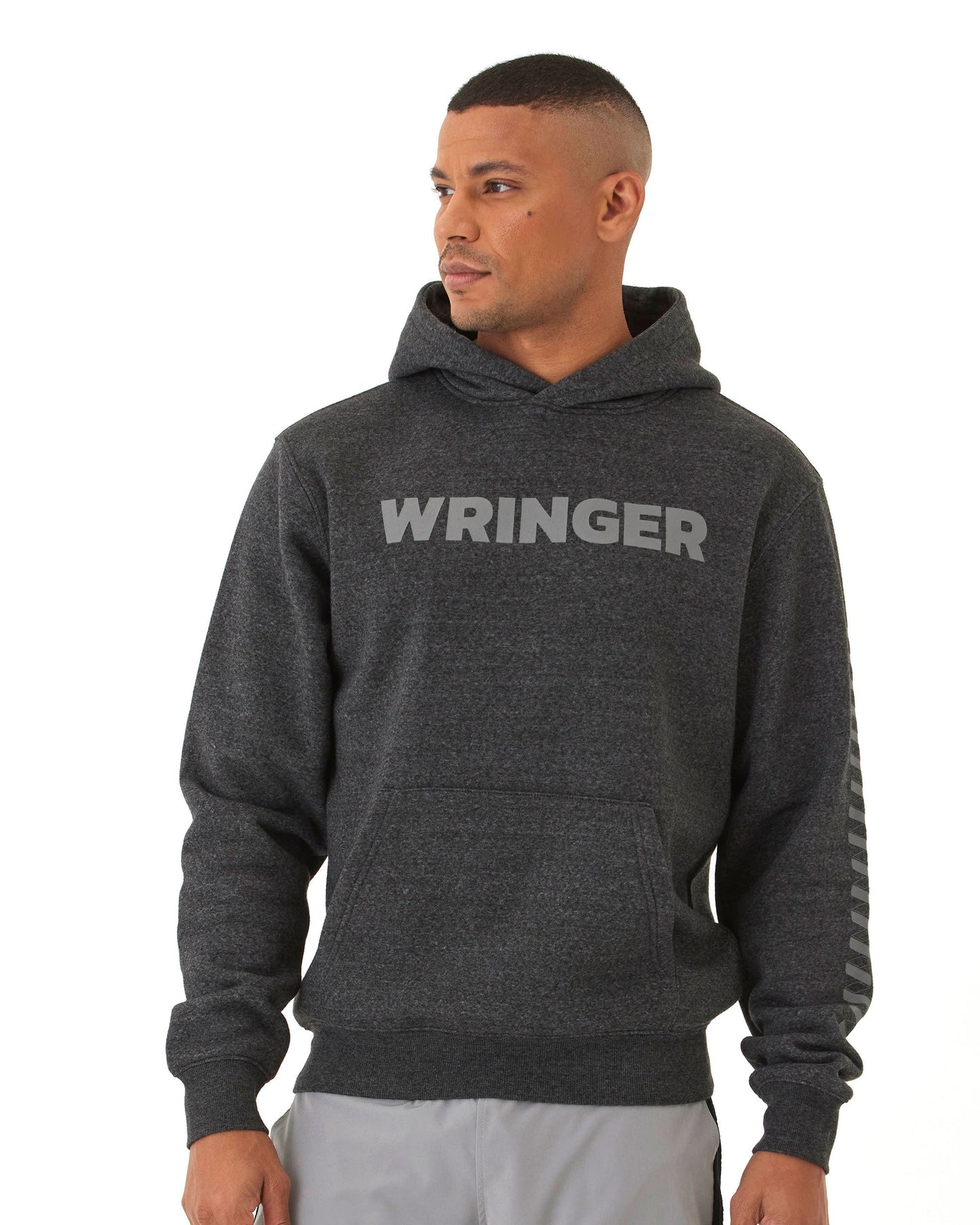 A man stands against a white background, wearing the Men's Core Wringer Graphic Hoodie from Wringer Wear. "WRINGER" is boldly printed across the chest as he looks to his left, showcasing this durable athletic hoodie.