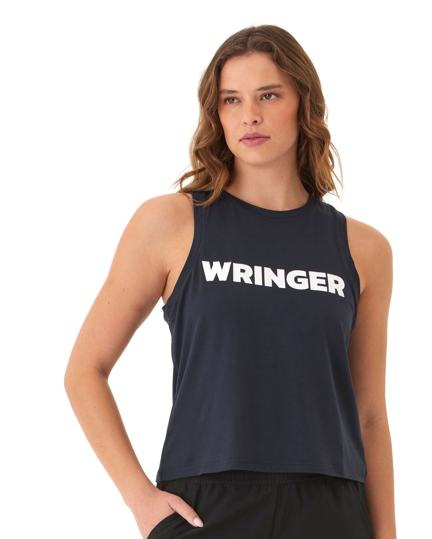 A woman with wavy brown hair wears the Wringer Wear Women's Performance Wringer Tank in dark navy, featuring "WRINGER" in bold white letters. The sleeveless, breathable top is shown against a plain white background as she looks to the side.
