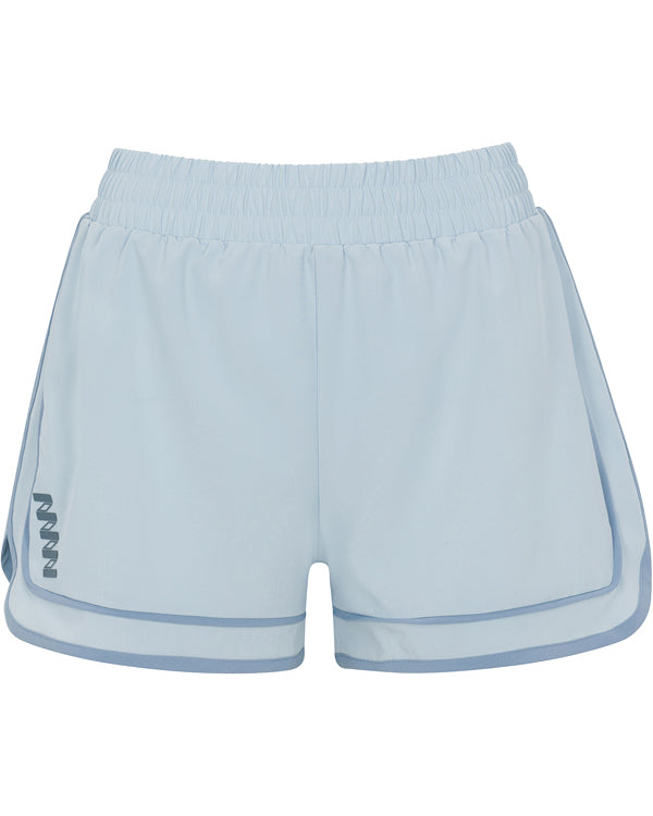 The Sierra Short by Wringer Wear features a light blue athletic silhouette with an elastic waistband, rounded side seams, dark blue trim, and a W logo on the left leg. These unisex shorts deliver comfort and style for all-court performance.