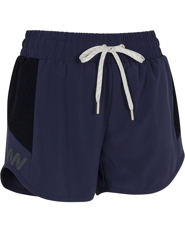 The Wringer Wear Moab Short features navy blue moisture-wicking fabric, an elastic waistband with a white drawstring, black side panels, reflective logo, relaxed fit, and curved hem—perfect for athletic performance.