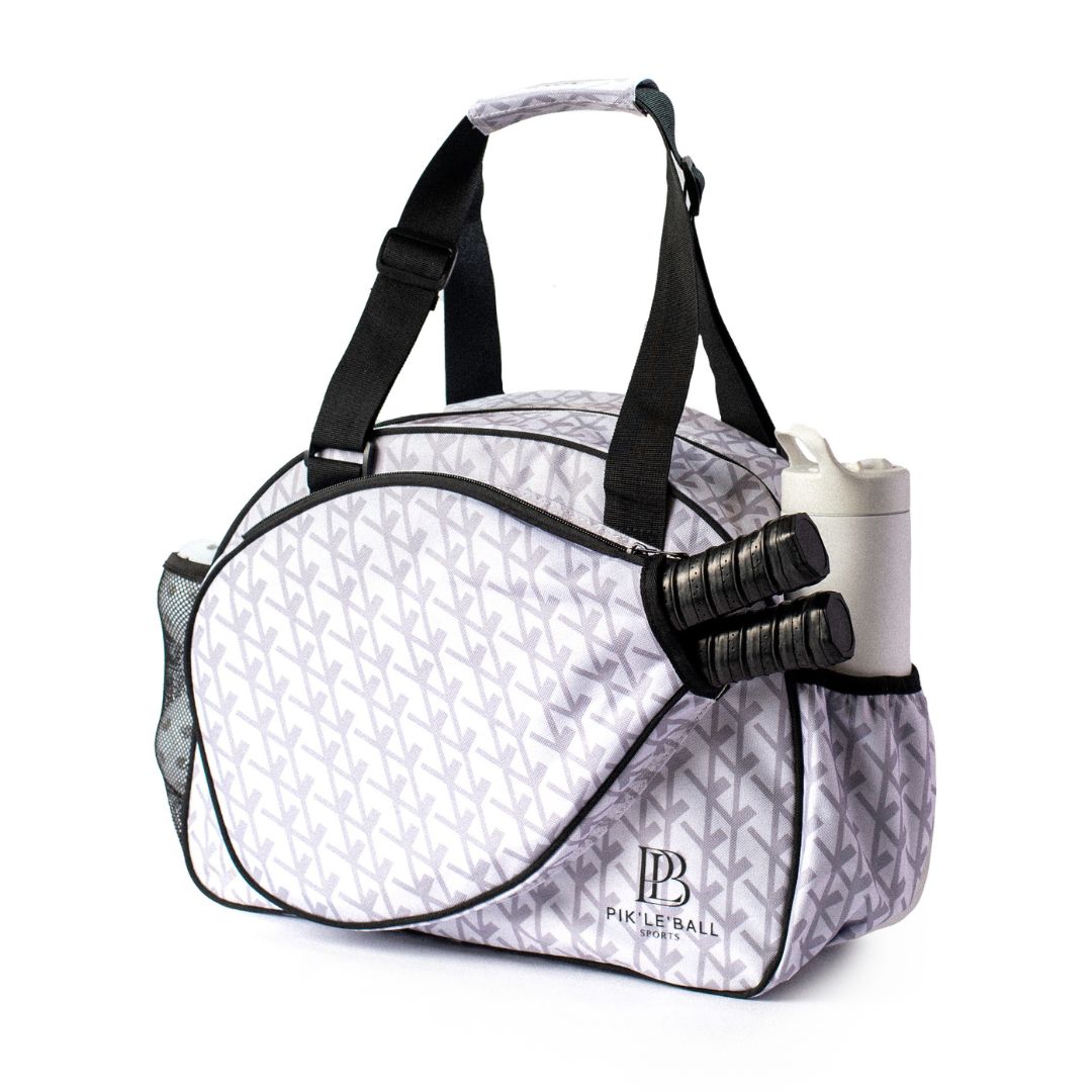 The Court Couture Premium Women's Pickleball Bag by Pik'le'Ball Sports features a gray and white geometric design, black straps, multiple compartments, a paddle sleeve, outer left mesh pocket, and space for two paddles and a water bottle.