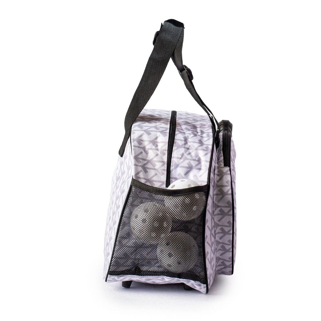 The Pik'le'Ball Sports Court Couture White Premium Women's Pickleball Bag stands upright, displaying gray and white patterns, a side mesh pocket with three white balls, black handles, and a top zipper against a plain white background.