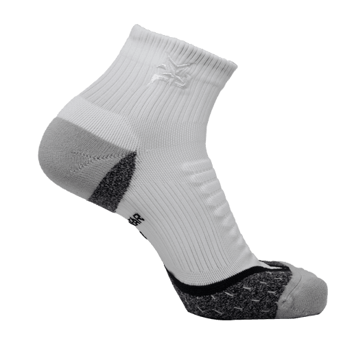 The iReliev AMP Ankle Compression Sock is shown upright, highlighting its white ribbed upper, gray cushioned heel and toe, black accents, moisture-wicking fabric, arch support, and textured grip pattern.
