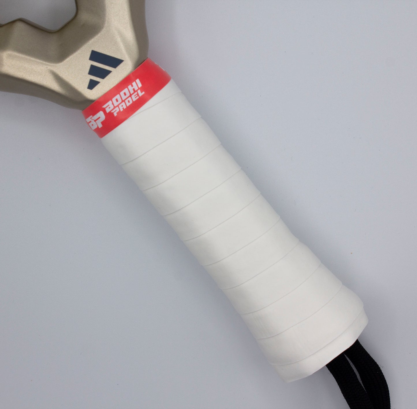 Close-up of a paddle racket handle wrapped in Bodhi Performance PROtack™ Premium Padel Overgrips for moisture absorption, featuring a red "3D Padel" band, metallic upper handle with black Adidas logo, and a black wrist strap at the bottom.