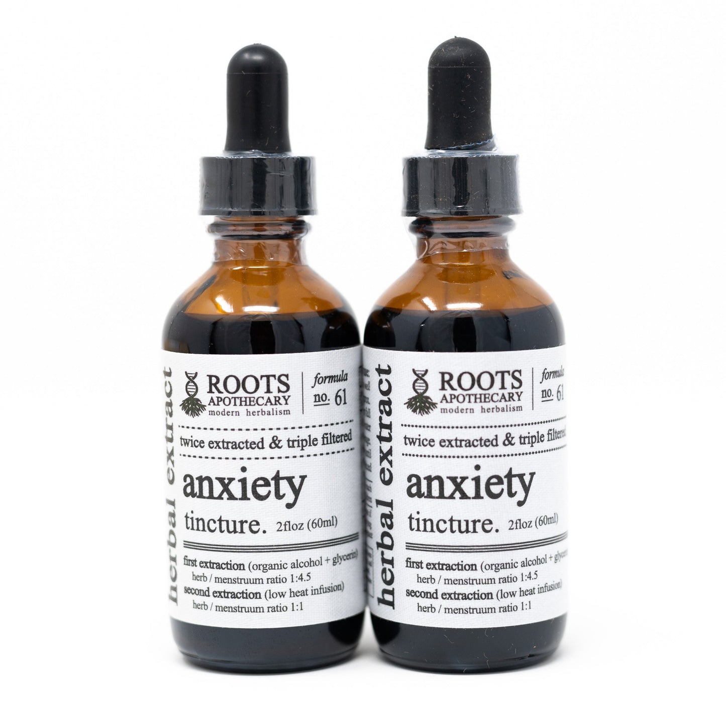 Two brown glass dropper bottles labeled Roots Apothecary anxiety tincture stand side by side, each with a black dropper cap and white label. These tinctures are formulated to calm mental tension and support adrenal balance for herbal anxiety relief.