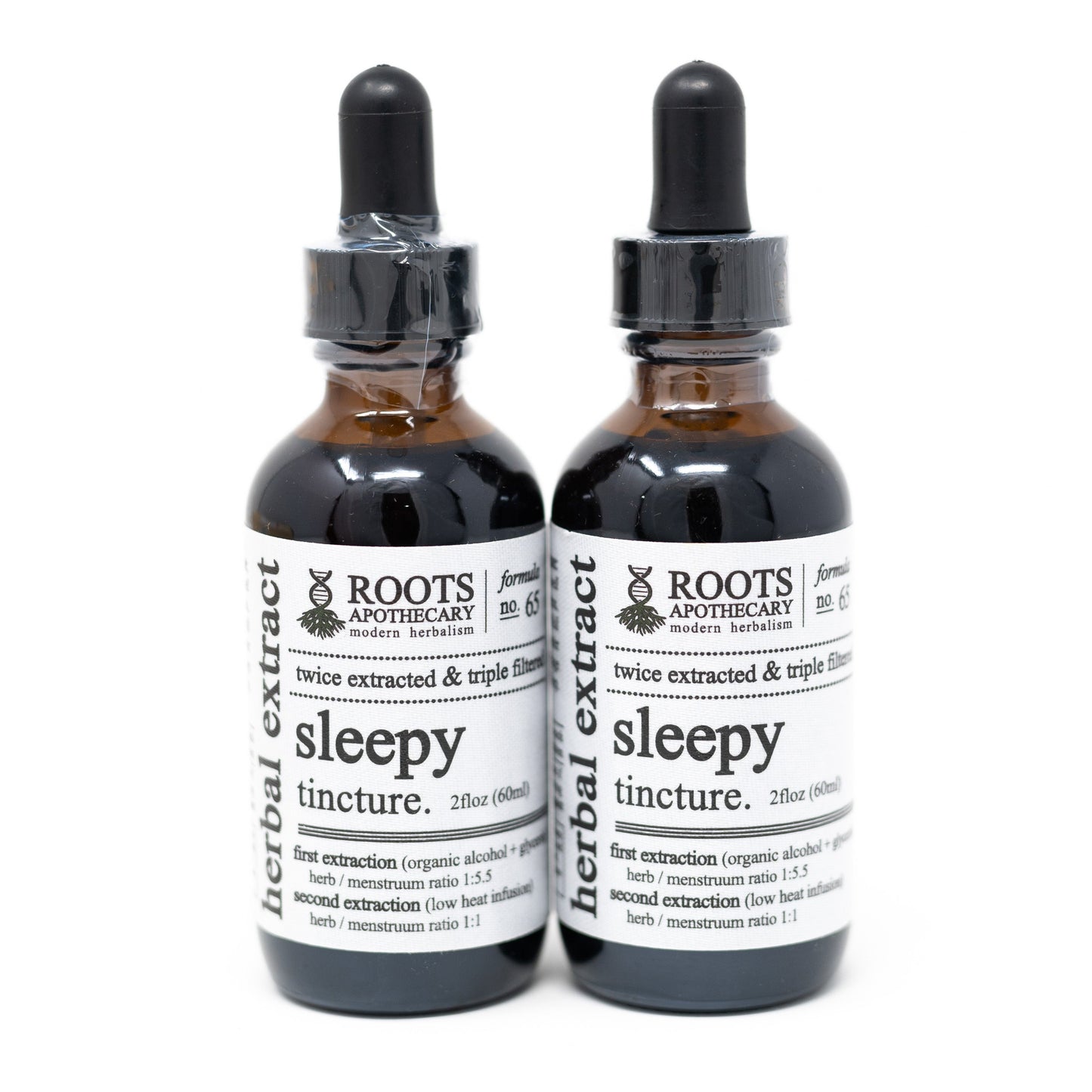 Two brown glass dropper bottles of Roots Apothecary sleepy tincture stand side by side. The white labels list dosing and herbal ingredients for natural sleep support, and each bottle is topped with a black dropper.