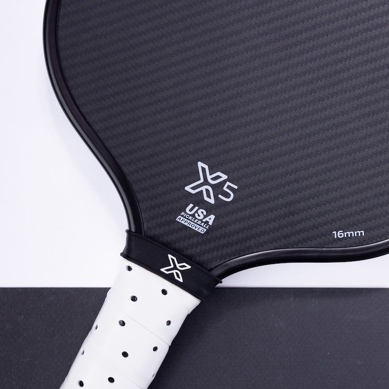 Close-up of the body helix X5 Kevlar Pickleball Paddle featuring a black face with subtle diagonal carbon fiber pattern, honeycomb core, white “X5” logo, “USAP Approved,” “16mm,” and a handle with cushioned, perforated white grip tape.