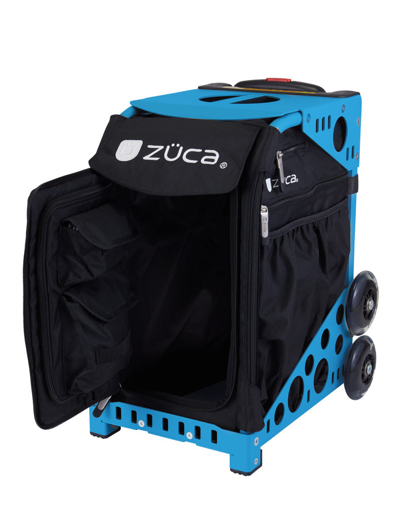 The ZUCA Pickleball Sport Black/Black rolling bag features a black zippered insert, open front flap revealing organized interior, large side wheels, a top handle, metal frame with circular cutouts, and ZÜCA logos on the flap and side pocket.