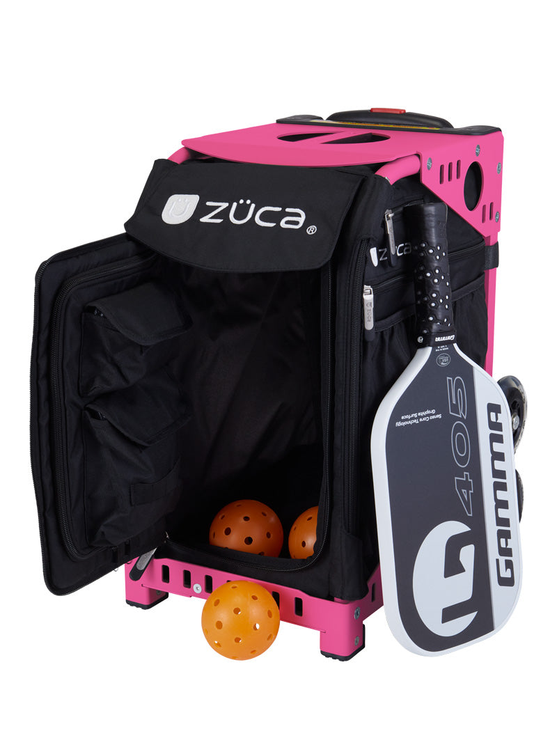 A ZUCA Pickleball Sport Black/Black rolling bag with its front pocket open shows yellow pickleballs inside. A black-and-white Gamma G 405 paddle is attached, highlighting the bag’s ample storage and portability.