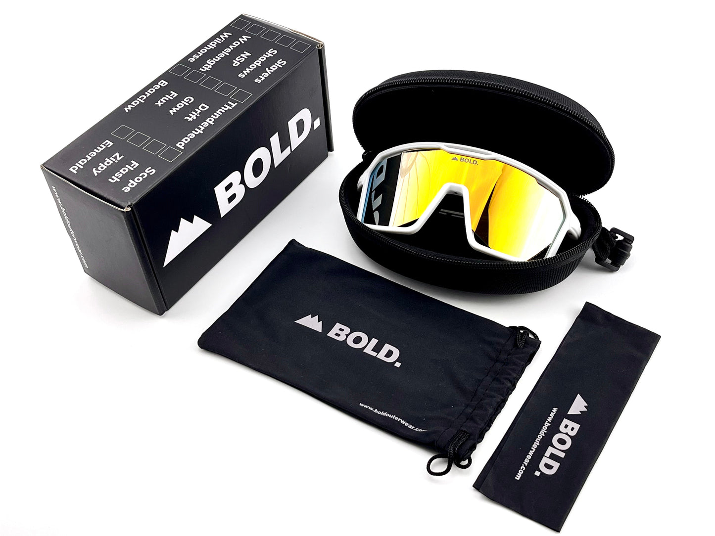 A pair of BOLD Flux Performance Sunglasses by boldouterwear with yellow-tinted UV lenses rests in a black zip case beside a branded box. Two black BOLD pouches, one drawstring and one rectangular, are displayed on a white background.