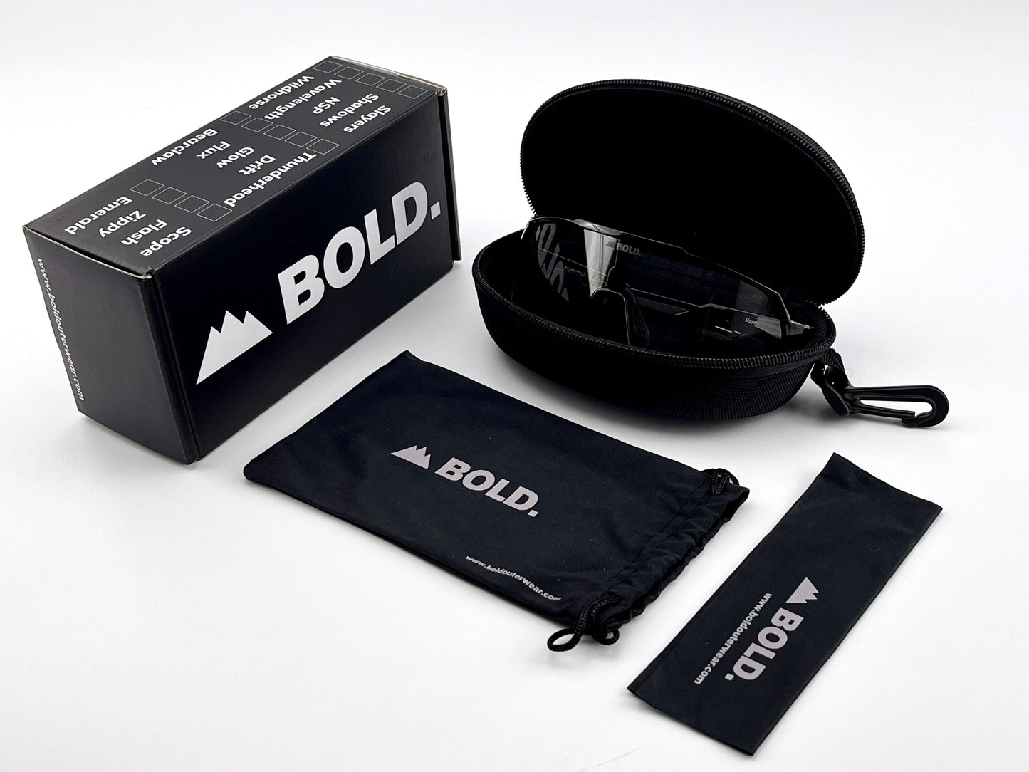 A set of boldouterwear BOLD Slayers Photochromic Sunglasses is shown on a white surface with a zippered hard case, black box, soft pouch, and cleaning cloth—each featuring the boldouterwear logo in white.